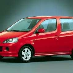 Czerwony Daihatsu YRV, kompaktowy samochód miejski, prezentuje się na ciemnym tle.