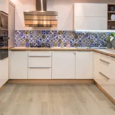 Nowoczesna kuchnia z błyszczącymi frontami i kolorową mozaiką. Zastanawiasz się, jakie panele do kuchni wybrać? Ta inspiracja pokazuje, jak efektownie mogą wyglądać płytki.