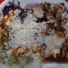 Kebab w pudełku z mięsem, warzywami, serem i sosami.