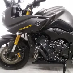 Ciemnoszary motocykl Yamaha Fazer z żółtym napisem "FAZER" na owiewce. Widoczny przód z reflektorem, przednie zawieszenie i silnik.