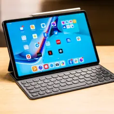 Tablet Huawei z klawiaturą i rysikiem, na ekranie widoczne ikony aplikacji, m.in. E-mail, Netflix, Office.
