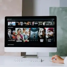 Komputer wyświetla Netflix, pokazując popularne seriale i filmy. To właśnie jest streaming – oglądanie treści online.