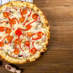 Pyszna pizza z pomidorkami i papryką, idealna na pytanie "gdzie zjesc Mielno".