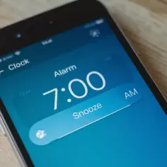 Budzik iPhone ustawiony na 7:00. Dźwięk alarmu zaraz się odezwie, ale można go jeszcze odłożyć.