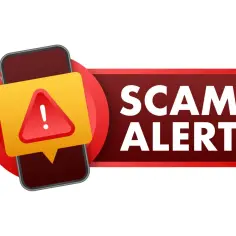 Ostrzeżenie przed oszustwem (scam co to) na telefonie. Czerwony trójkąt z wykrzyknikiem na żółtym tle.