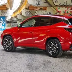 Czerwony Hyundai Tucson 1.6 benzyna 150KM pod mostem z graffiti. Zastanawiasz się, ile pali?
