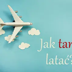 Model samolotu latający wśród papierowych chmurek na niebieskim tle.