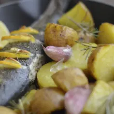 Pieczony seabass z ziemniakami, cytryną i czosnkiem.