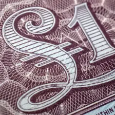 £ – symbol £ to waluta Wielkiej Brytanii. Zbliżenie na banknot z ozdobnym wzorem.