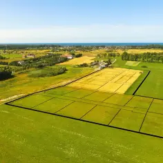Działka budowlana podzielona na mniejsze parcele, z widokiem na morze i zabudowania. Planujesz budowę? Pamiętaj o podatku za działkę budowlaną.