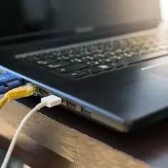 Kabel VGA i sieciowy podłączone do laptopa. Dowiedz się, jak podłączyć laptop z monitorem, aby rozszerzyć przestrzeń roboczą.