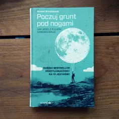 Okładka książki "Poczuj grunt pod nogami". Człowiek trzyma balon w kształcie księżyca, jakby chciał uciec od poczucia, że jestem nikim.