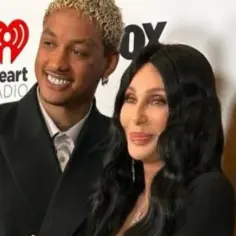 Cher i jej młodszy partner pozują na ściance iHeartRadio.