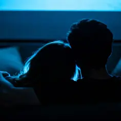 Para ogląda filmy akcji, wtuleni w siebie na kanapie, w blasku niebieskiego ekranu.