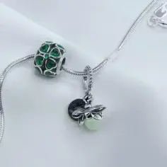 Zielony charms z koniczynkami i pszczółka na bransoletce. Czy charmsy z Apartu pasują do Pandory? Tak, wyglądają świetnie razem!