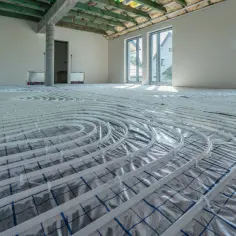 Instalacja ogrzewania podłogowego w nowym domu. Rozłożone rury zapowiadają komfort i niższy koszt ogrzewania.