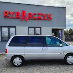 Srebrny Citroen Evasion zaparkowany przed budynkiem z napisem "RYBARCZYK".