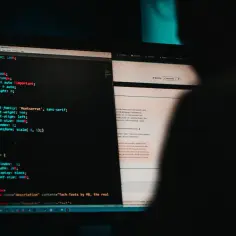Kodowanie na ekranie monitora, symbolizujące potencjalny atak hakerski.