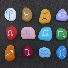 Kolorowe kamienie z symbolami zodiaku: strzelec i wodnik wśród innych znaków.