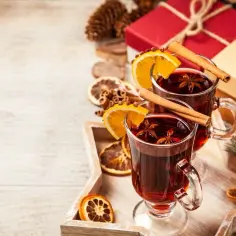 Dwa kubki aromatycznego grzańca z pomarańczą i cynamonem, idealne na zimowe wieczory.