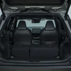 Otwarty bagażnik Toyoty Corolla Cross, pokazujący przestronne wnętrze i złożone tylne siedzenia. Idealny do przewożenia bagażu, co potwierdzają jego wymiary.