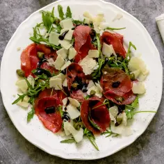 Sałatka z bresaolą, rukolą, parmezanem i kaparami, polana sosem balsamicznym. Tak wygląda pyszna bresaola, co to jest?