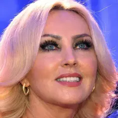 Polska piosenkarka z blond włosami i niebieskimi oczami, w złotych kolczykach.