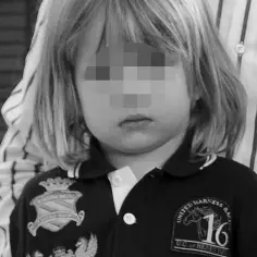 Mały Maks Chajzer w czarnej koszulce z herbem i napisem "UNITED HARNESS RACING 16 UC of BENETTON". Obok widać fragment ubrania Filipa Chajzera.