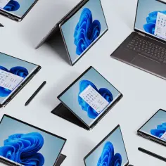 Laptopy z ekranami dotykowymi i rysikami, prezentujące pulpit systemu jaki jest najnowszy Windows 11.