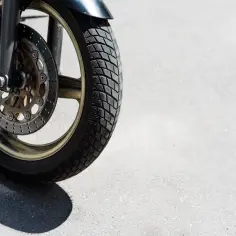 Przednia opona motocyklowa z tarczą hamulcową, gotowa do testu opon motocyklowych na asfalcie.