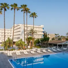 Basen i leżaki przy hotelu TUI Suneo Santa Ponsa, otoczone palmami i zielenią, zapraszają do relaksu.