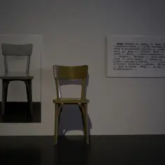 Dwa krzesła i fragment słownika definiujący słowo "chair" – to przykład konceptualizmu, gdzie idea jest ważniejsza od formy.