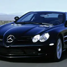 Czarny SLR McLaren pędzi po pustynnej drodze, jego sylwetka lśni w słońcu.