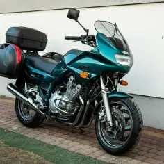 Zielony motocykl Yamaha XJ 900 Diversion z kuframi, gotowy na podróż. Dane techniczne tego modelu są imponujące.