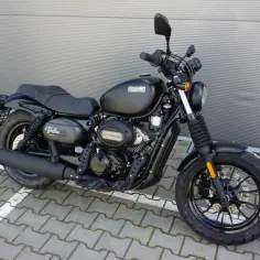 Czarny motocykl Hyosung GV125S Bobber stoi na kostce brukowej.