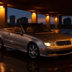 Srebrny kabriolet Mercedes CLK 200 stoi na mokrym parkingu pod wieczornym niebem, odbijając światła latarni.