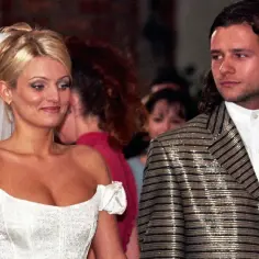 Młody Radosław Majdan w błyszczącej marynarce obok panny młodej w białej sukni.