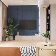 Nowoczesny salon z niebieską ścianą, telewizorem, roślinami i drewnianym stolikiem.