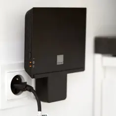 Czarny funbox 6 Orange podłączony do gniazdka. Urządzenie z diodami sygnalizującymi pracę.