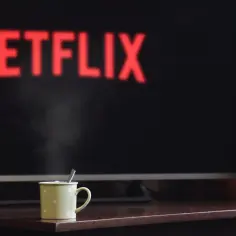 Gorąca herbata i seans na Netflix NW-2-5. Para unosi się z kubka na tle ekranu z logo.
