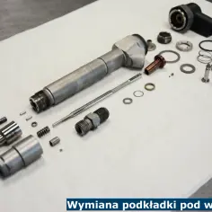 Rozłożony wtryskiwacz i jego części, w tym podkładka pod wtrysk, gotowe do wymiany.