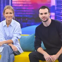 Olga Frycz z partnerem siedzą na kanapie w studiu.