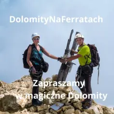 Dwaj alpiniści, gotowi na przygodę na ferracie w Dolomitach, pozdrawiają z górskiego szczytu.