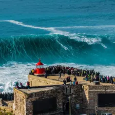 Tłum ludzi obserwuje surferów na gigantycznych falach Atlantyku. To dowód, że Portugalia ma dostęp do morza i to jaki!