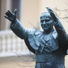 Pomnik Jana Pawła II z podniesionymi rękami. W senniku papież Jan Paweł II symbolizuje nadzieję i duchowe przewodnictwo.