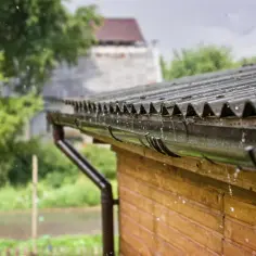 Deszcz spływa z dachu, a rynna zbiera wodę. Nie ma tu nic o tym, jak podłączyć mauser do rynny.