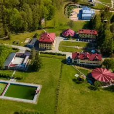 Teren z basenem i budynkami o czerwonych dachach, otoczony zielenią. Idealne miejsce na odkrywanie wapienne atrakcje regionu.