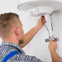 Instalator sprawdza podłączenie bojlera. Dowiedz się, ile za wymianę bojlera zapłacisz.