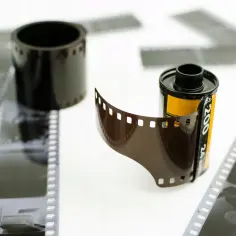 Zastanawiasz się, ile kosztuje wywołanie kliszy? Na zdjęciu rolki filmu fotograficznego i wywołane negatywy.