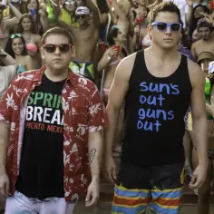 Schmidt i Jenko na imprezie w stylu "23 Jump Street". Schmidt w koszulce "Spring Break" i hawajskiej koszuli, Jenko w podkoszulku "Sun's out, guns out".